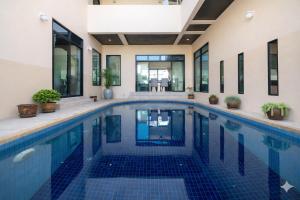 a swimming pool with blue tiles in a house at Rawai Escape 5BR Pool Villa Close to Everything in Ban Saiyuan (1)
