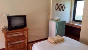 a room with a television and a small refrigerator at Sinsawat Resort in Uttaradit +62 photos