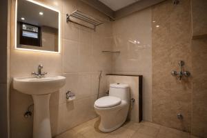 a bathroom with a toilet and a sink at Hotel Well Suites Koramangala in Bangalore