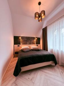 a bedroom with a large bed and a chandelier at Shiro Nord Rooms in Predeal