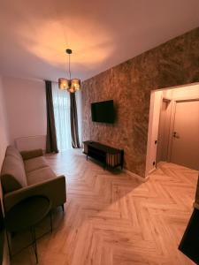 a living room with a couch and a flat screen tv at Shiro Nord Rooms in Predeal +32 photos