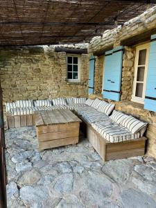 a wooden bench sitting in front of a stone building at La maison Haut-perché townhouse with view and jacuzzi in Saumane-de-Vaucluse