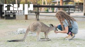 a young girl petting a kangaroo in a park at Layla Glamping in Nir Dawid