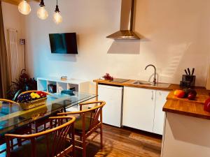 a kitchen with a table with chairs and a sink at Primiero Suite 3 downtown, garden in Transacqua
