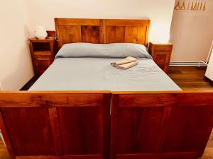 a large wooden bed in a bedroom with a wooden frame at Primiero Suite 3 downtown, garden in Transacqua