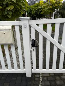 a white picket fence with a meter on it at Apartament Premium Pola in Bolesławiec