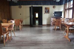 ポドグジンにあるDom wczasowy Lubuszaninのダイニングルーム(テーブル、椅子、テレビ付)