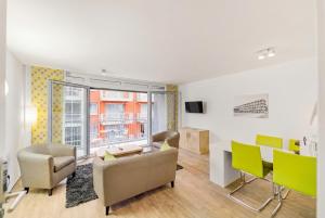 a living room with a couch and a table and chairs at ADAPT APARTMENT HOTEL BERLIN - Adlershof in Berlin