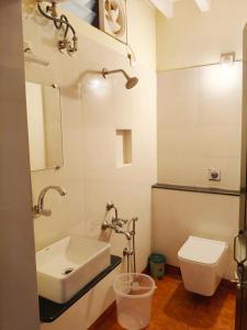 a bathroom with a sink and a toilet at La Maison D'Ellappa in Pondicherry