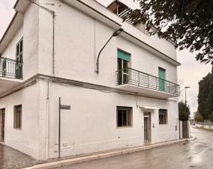 a white building with two balconies on a street at Il Barbagianni in Chieuti