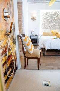 a room with a bed and a chair with a painting at Casa Rachele alloggio turistico in Sabina in Poggio Mirteto +14 photos