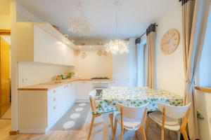 a kitchen with a table and chairs and a clock at Appartamento Lucia in Penia