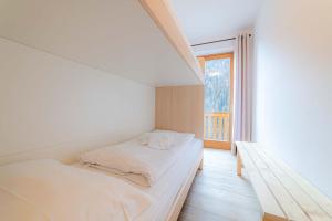 a white room with a bed and a window at Appartamento Lucia in Penia