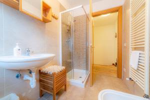 a bathroom with a sink and a shower at Appartamento Lucia in Penia +21 photos