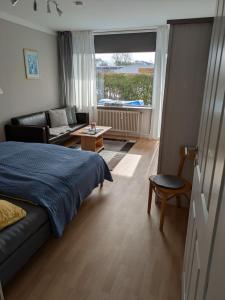 a bedroom with a bed and a living room at Appartementhaus Martel - Adults Only in Travemünde