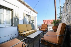 a row of chairs and tables on a balcony at Tepeleni, Parga Apts with Pool in Agiá