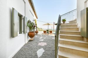 a hallway with stairs and potted plants and an umbrella at Tepeleni, Parga Apts with Pool in Agiá +24 photos