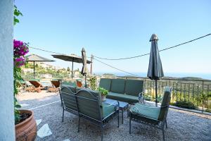 a table with chairs and an umbrella on a patio at Tepeleni, Parga Apts with Pool in Agiá