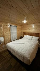 a bedroom with a large bed in a wooden room at 036 Tiny Home nr Grand Canyon South Rim Sleeps 8 - Full Kitchen in Valle