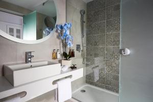 a bathroom with a sink and a tub and a mirror at Mythos Palace Resort & Spa in Georgioupolis