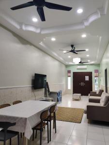 a living room with a table and a ceiling fan at AZALEA Homestay Segamat in Segamat