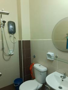 a bathroom with a toilet and a sink and a mirror at AZALEA Homestay Segamat in Segamat +10 photos