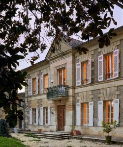 ein altes Steinhaus mit Balkon in der Unterkunft Malis Castera Le Petit Château in Saint-Jean-de-Blaignac