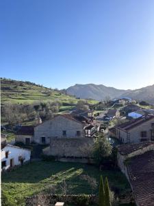 a village with houses and mountains in the background at La ventanuca del Valle in Bielva