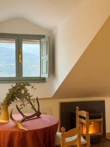 a table with a plant on top of it next to a fireplace at La ventanuca del Valle in Bielva