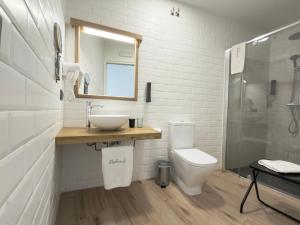 a bathroom with a sink and a toilet and a mirror at Balhondo Open Village in Puebla de Alcocer +58 photos