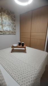 a room with a bed with two black cups on a table at Thermi Luxury apartments in Thermi