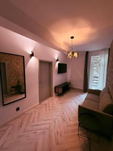 a living room with a couch and a television at Shiro Nord Rooms in Predeal