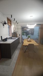 a kitchen with a wooden table and a dining room at Thermi Luxury apartments in Thermi +11 photos