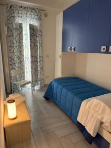 a bedroom with a bed and a table and a window at Eleven Home in Bari