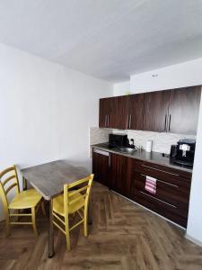a kitchen with a table and chairs in a room at Apartmán PRAHA in Martin
