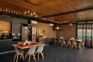 a kitchen and dining room with a table and chairs at Sun Garden Glamping Domes in Călimăneşti