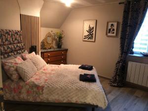 a bedroom with a bed with a dresser and a window at Pensée in Huelgoat