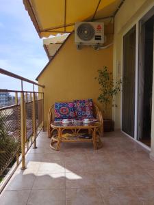 a patio with a couch and a table on a balcony at Alegria in Varna City