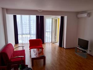 a living room with red chairs and a television at Alegria in Varna City