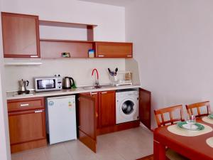 a small kitchen with a washing machine and a dishwasher at Alegria in Varna City
