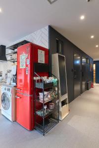 a red refrigerator in a kitchen next to a washing machine at Artravel Myeongdong in Seoul