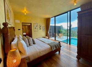 a bedroom with a bed and a large glass window at The Capoe House - By Mountain Boutiques Luxury Collection in Haputale