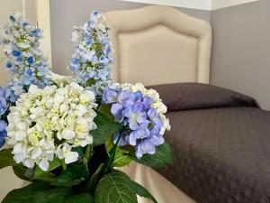 a vase filled with blue and white flowers on a bed at Le Due Sorelle in Savio di Ravenna