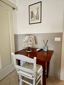 a wooden desk with a lamp and a white chair at Le Due Sorelle in Savio di Ravenna