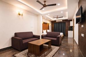 a living room with two chairs and a couch at Hotel Well Suites Koramangala in Bangalore