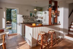 a kitchen with a counter and two stools at KIS CINKE Guesthouse in Tahitótfalu