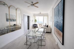 a living room with a glass table and a couch at Mackenzie Beachfront Panorama in Larnaca