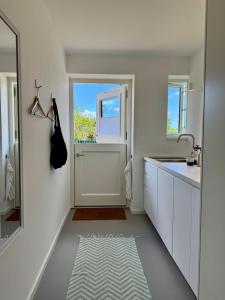 a white bathroom with a sink and a window at Nije Haven Bed & Breakfast in Wrixum +56 photos