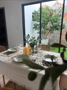 a table with a white table cloth and glasses on it at Duchess Home Taman Colonial in Raub