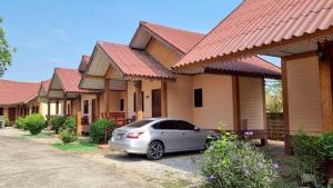 a car parked in front of a row of houses at Sinsawat Resort in Uttaradit